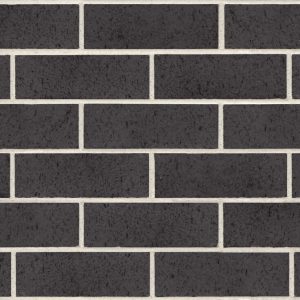 Close-up of a dark brick wall with light gray mortar joints visible between bricks.