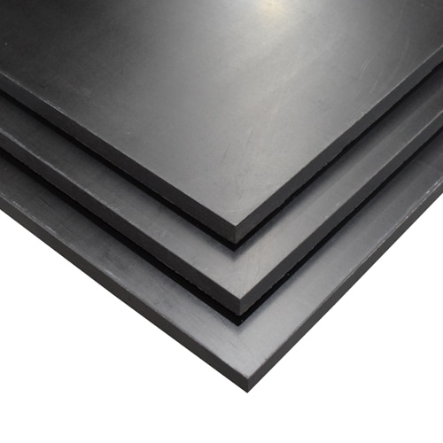 Stacked dark gray metal plates viewed from an angle, showing beveled edges and layered corners.