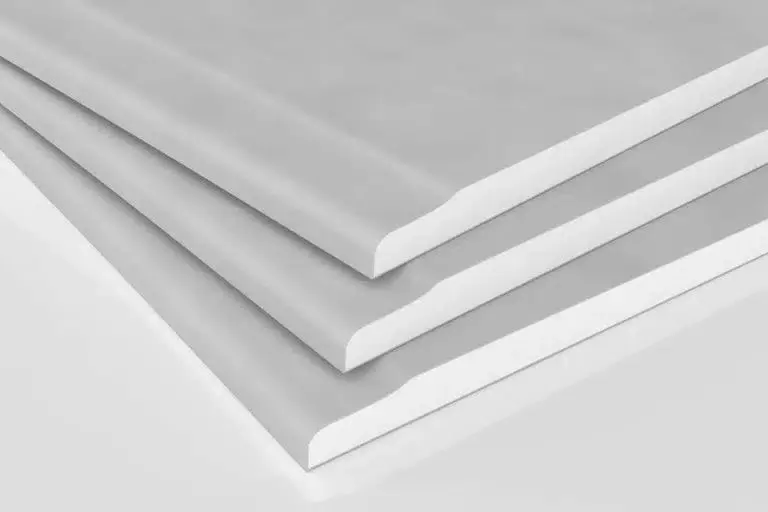 Stack of white foam insulation boards stacked at a slight angle, showing rounded edges and layered thicknesses.