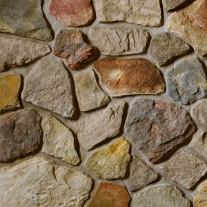 Close-up of a stone wall built from irregular brown, gray, and tan stones with mortar.