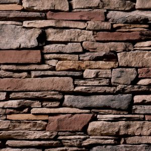 Staggered dry-stone wall with irregular brown and gray stones set in horizontal layers