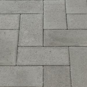 Gray concrete pavers arranged in a rectangular, interlocking pattern for a walkway or patio surface.