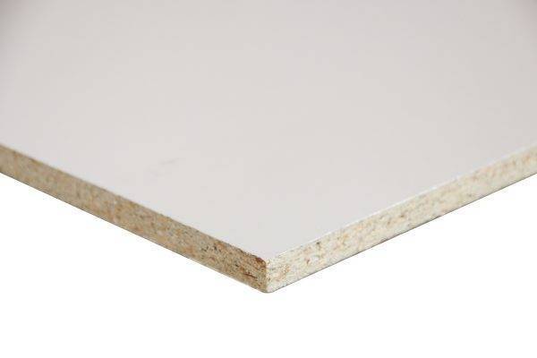 Corner of a white melamine-faced particleboard, exposing the beige wood core edge in the corner. Spirit: close-up of the edge.